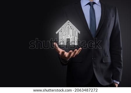 Businessman hold house icon.Smart home controlled, intelligent house, and home automation app concept.Pcb design and person with smart phone. Innovation technology internet Network Concept
