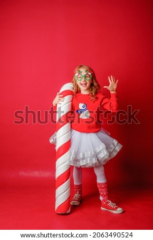 little  girl on a red the background with a large caramel 