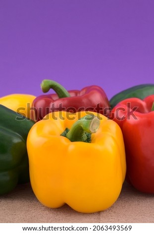 Colourful bell peppers, vegetables on grunge cement against blue gradient background. Royalty-Free Stock Photo #2063493569