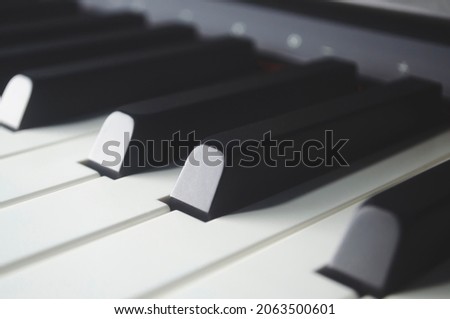 Piano keyboard background with selective focus. Cool color toned image. Piano keys side view with shallow depth of field.