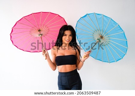 Attractive young woman posing with colorful umbrellas