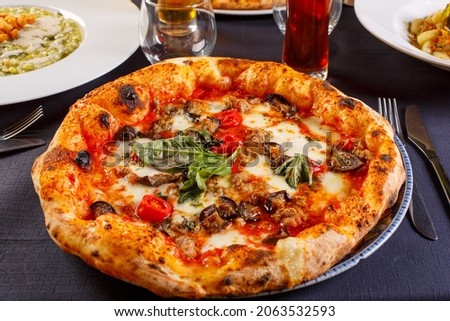Neapolitan pizza with tomato sauce, mozzarella, fresh basil and fried eggplant