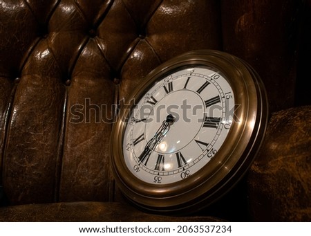 Photo of vintage wall clock in a old chester sofa