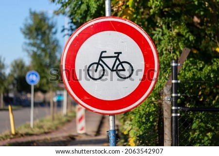 Stop and no entry traffic sign with a pictogram of a bike on white background with vibrant red band surrounding it. Prohibited for bikeriders to continue. End of bicycle path.