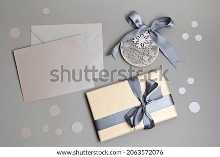 Christmas background with gift box in gray colors. Xmas celebration, greetings, preparation for winter holidays. Festive mockup, top view, flat lay with copy space