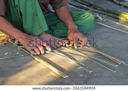 Ninh Binh, Vietnam - 25 Oct 2021: knitting bamboo frame by hand in the sunset Royalty-Free Stock Photo #2063584904
