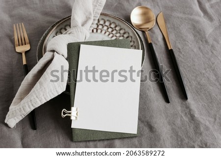 card mockup on table place setting neutral gray color linen tablecloth background top view. Space for text. Sheet card template, wedding invitation, greetings,menu.