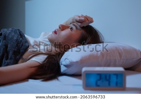 Asian women opened eyes lying on the bed have an insomnia problems. Royalty-Free Stock Photo #2063596733