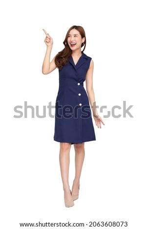 Young Asian woman smiling and pointing finger to empty copy space isolated on white background, Full body composition Royalty-Free Stock Photo #2063608073
