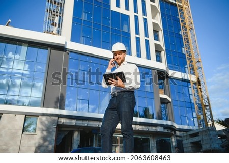 Construction engineer with the tablet pictures of objects on a construction site