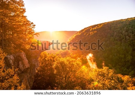 Sunrise at Whitaker Point, known as Hawksbill Crag, during the fall color change of the leaves. Hawksbill is a popular tourist site in the state of Arkansas. Royalty-Free Stock Photo #2063631896