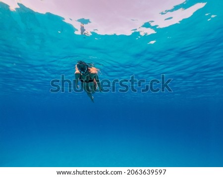Underwater photo of beautiful woman snorkeling 