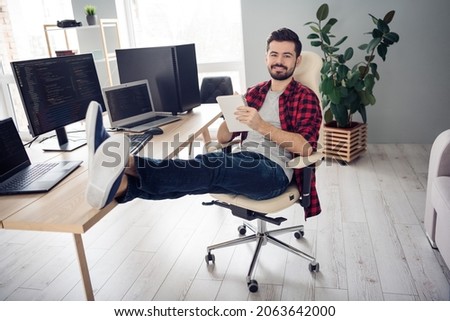Full body photo of happy young cheerful man write notebook good mood coder pc sit table indoors inside office