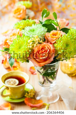Autumnal table setting with  bunch of autumn flowers and cup of tea