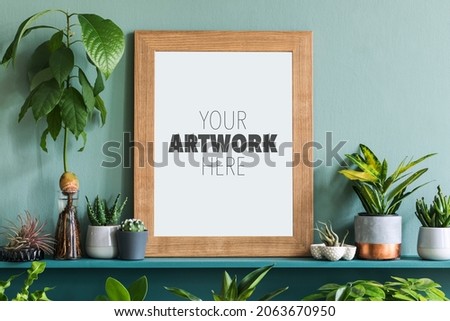 Interior design of living room with mock up photo frame on the green shelf with plants in different hipster pots, decoration and elegant personal accessories. Home gardening. Template. 