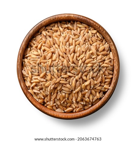 Wholegrain spelt farro in wooden bowl isolated on white background. View from above. Royalty-Free Stock Photo #2063674763