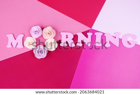 The inscription "morning". Pink letters and flowers on a multicolored background.Good morning greeting card