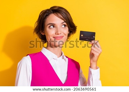 Photo of pretty cute young woman dressed pink suit holding credit card looking empty space isolated yellow color background
