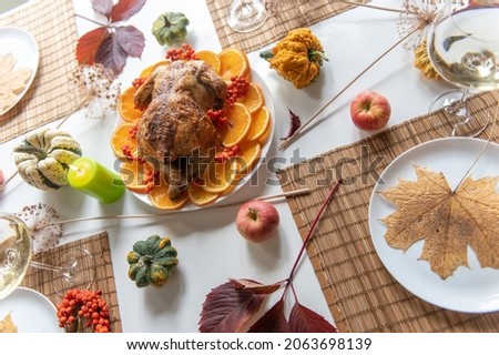 Thanksgiving celebration traditional dinner setting food concept. Top view on roasted turkey on a decorated table.