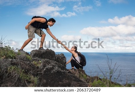 People helping each other hike up a mountain.  Giving a helping hand, challenging yourself, active lifestyle concept. Royalty-Free Stock Photo #2063720489