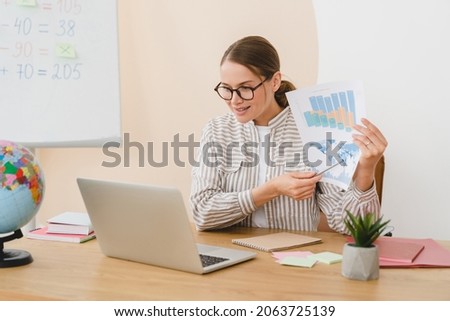 Young woman teacher lector tutor student explaining talking showing charts online at the school video lesson using laptop. Remote education, geography video call conference. Royalty-Free Stock Photo #2063725139