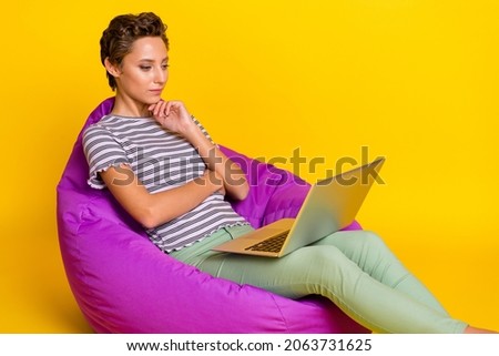 Photo of hr young lady sit on bag work laptop wear t-shirt jeans isolated on yellow background