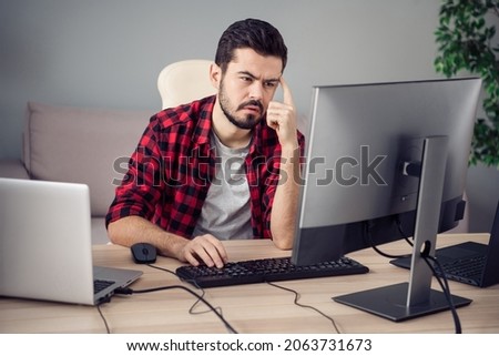 Photo of unhappy tired young man programmer browsing sit desk write computer pc indoors inside office workplace