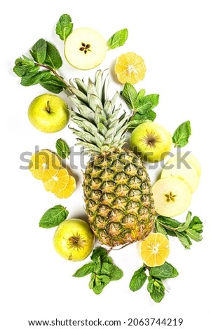 Pineapple with mint leaves, sliced apples and lemon, top view