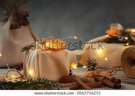Zero waste christmas concept. Packed in natural fabric gifts and decorations from natural materials with christmas lights