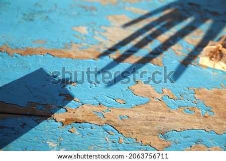Shadow reflection gift box with shadow reflection hand on blue (turquoise) old wooden background. Present box, creative picture. Holiday concept. Grunge table.