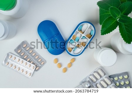 Top view of six day pill box with pills. Blue pill-box over light marble table. Open pill box and open boxes with pills or vitamins. Pill box for senior patient Royalty-Free Stock Photo #2063784719