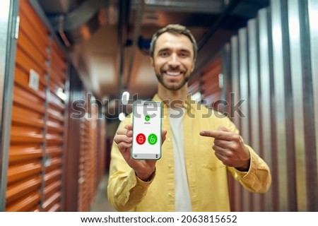 Joyful man pointing with finger at smartphone screen