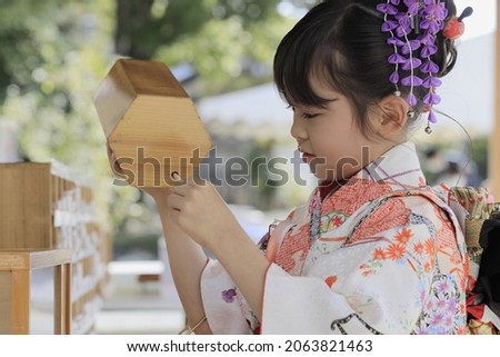 Japanese girl drawing Omikuji in Seven-Five-Three festival cloth (7 years old) Royalty-Free Stock Photo #2063821463