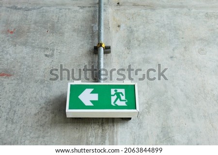 Fire exit signs are mounted on the wall.  inside the building