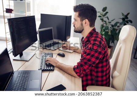Profile side photo of serious young man look screen write code web design sit desk indoors inside office workplace