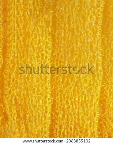 closeup, background, texture, large long vertical banner. heterogeneous surface structure bright saturated yellow sponge for washing dishes, kitchen, bath. full depth of field. 