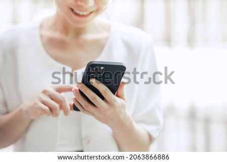 Happy woman hand holding mobile phone, she chatting online messaging and social network on mobile. copy space Royalty-Free Stock Photo #2063866886