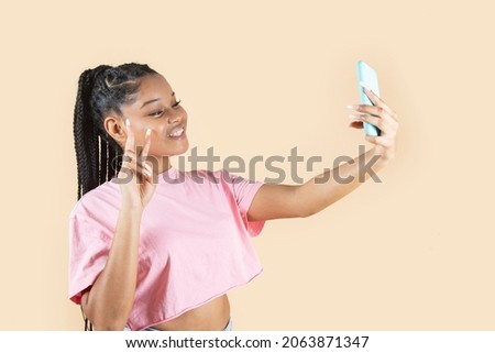 pretty latin hispanic woman taking photos of herself with a smartphone