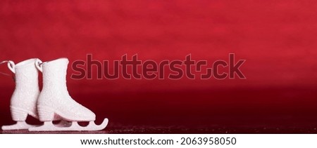 white ice skates on red isolated background christmas new year concept
