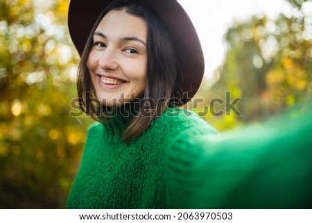 Beautiful smiling girl takes a selfie. Selfie on the street. The girl uses modern technology. Video call. Online conversation.