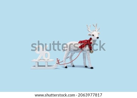 White Christmas reindeer on baby blue background with percentage sign on sledges. Merry Christmas and Happy New Year seasons sales or discounts concept. Edgeless banner minimal.