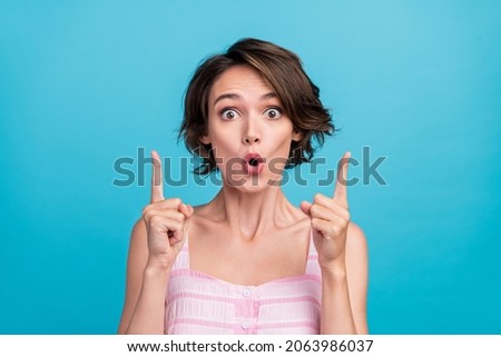 Photo of impressed young shop assistant lady point index up wear pink top isolated on blue color background