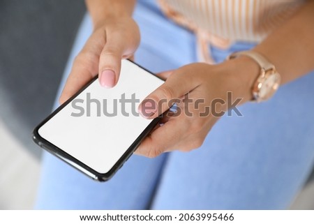 Young woman holding modern mobile phone, closeup