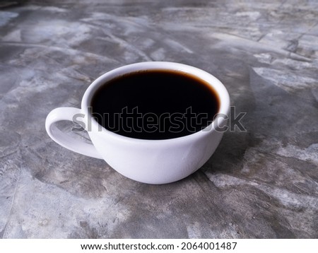 photo above white coffee cups with hot black coffee without sugar it is popular to drink in morning to help them stay awake and refreshed, and ready to work. Placed On table cement pattern Loft color