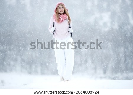 Woman in the winter in nature. A beautiful girl walks in the cold season. High quality photo
