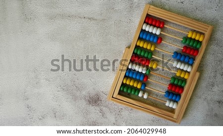 on the right, wooden children's abacus lie on a gray background, top view. preschool education for children