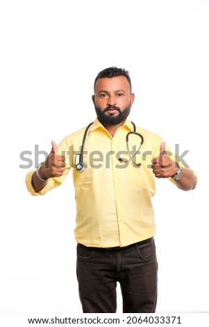 Young Doctor with a stethoscope and showing thumbs up over white background.