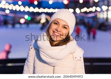 Happy young woman in winter near the ice rink. Christmas and winter concept.
