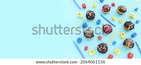 Image of jewish holiday Hanukkah with doughnuts and wooden dreidels (spinning top)