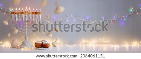 Religion image of jewish holiday Hanukkah background with menorah (traditional candelabra), doughnuts, spinning top and oil candles